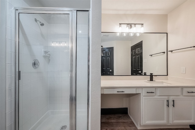 bathroom featuring hardwood / wood-style floors, vanity, and a shower with shower door