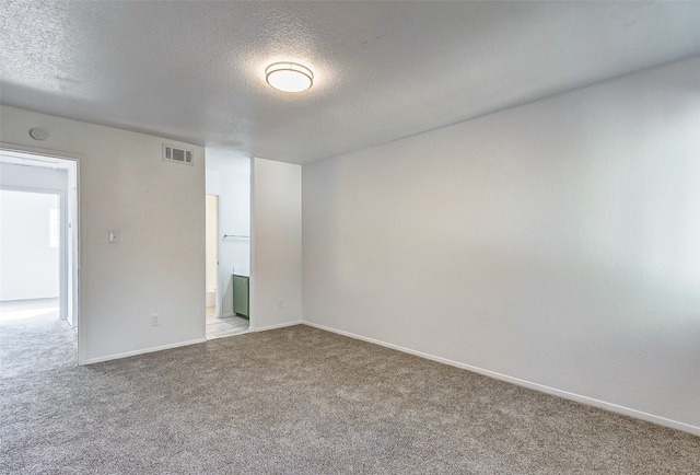 unfurnished room featuring carpet flooring and a textured ceiling