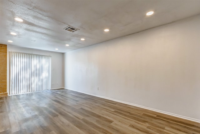 unfurnished room with hardwood / wood-style flooring