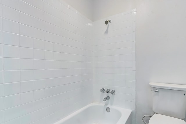 bathroom with toilet and tiled shower / bath