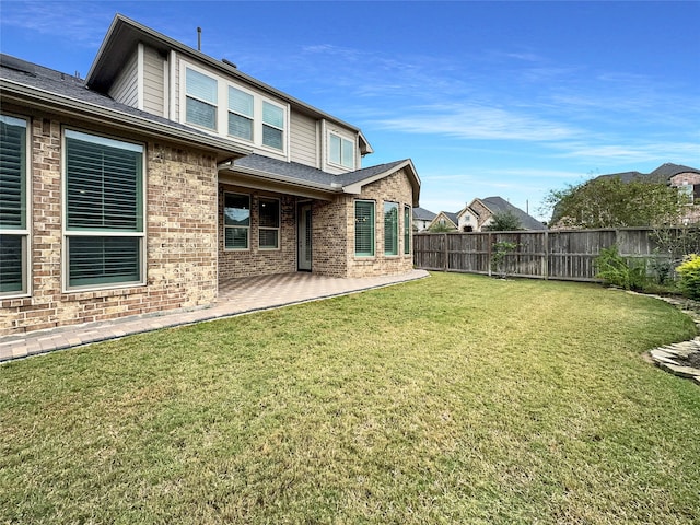 rear view of house featuring a patio and a yard