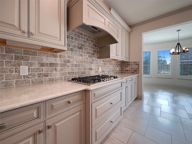 kitchen with tasteful backsplash, decorative light fixtures, an inviting chandelier, custom exhaust hood, and stainless steel gas cooktop