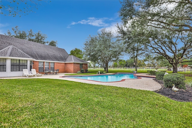 view of pool with a patio and a yard