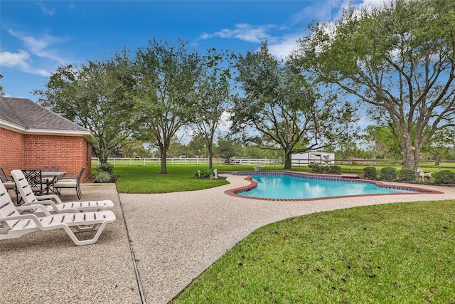 view of pool featuring a lawn and a patio