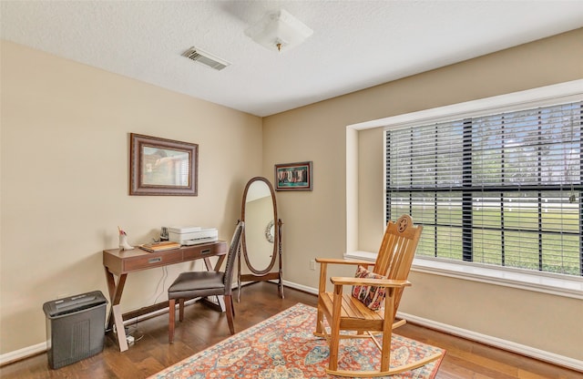 office area with dark hardwood / wood-style floors and a textured ceiling