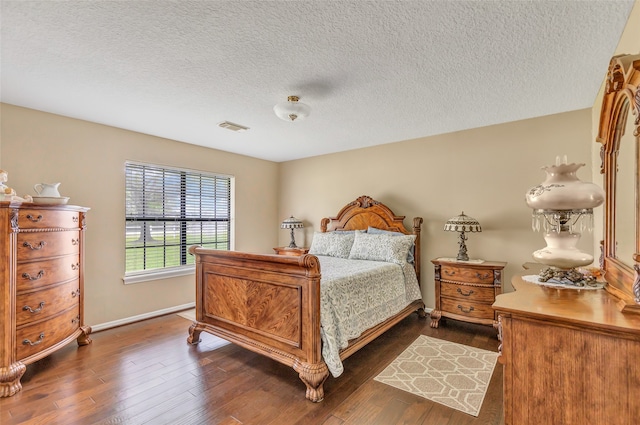 bedroom featuring dark hardwood / wood-style floors and a textured ceiling