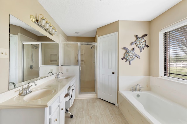 bathroom with vanity, a textured ceiling, and separate shower and tub