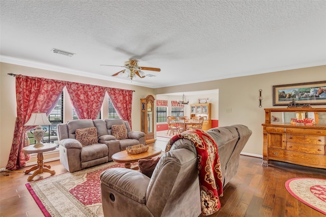 living room featuring hardwood / wood-style floors, ceiling fan, a textured ceiling, and ornamental molding