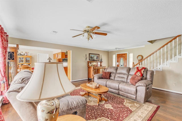 living room featuring hardwood / wood-style flooring, ceiling fan, and crown molding