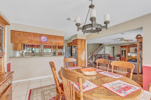 dining room featuring ceiling fan with notable chandelier and light tile patterned floors