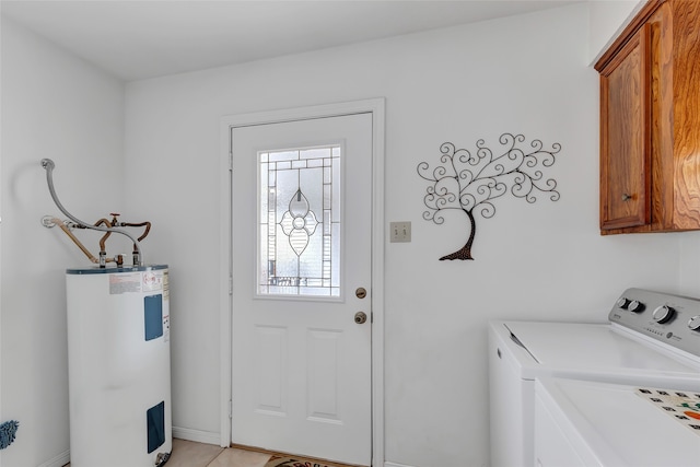 washroom with cabinets, light tile patterned flooring, water heater, and washing machine and clothes dryer