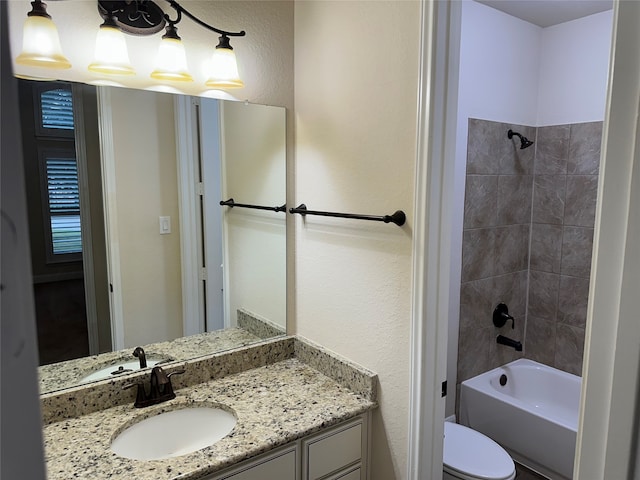 full bathroom with tiled shower / bath, toilet, and vanity