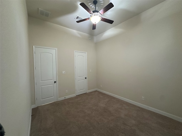 unfurnished room featuring ceiling fan and dark colored carpet