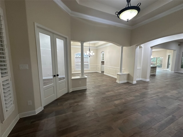 entryway with french doors, crown molding, ornate columns, dark hardwood / wood-style flooring, and a chandelier