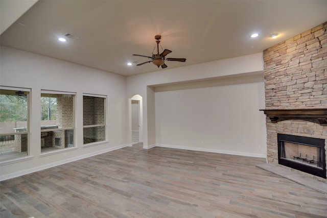 unfurnished living room with a fireplace, light hardwood / wood-style floors, and ceiling fan