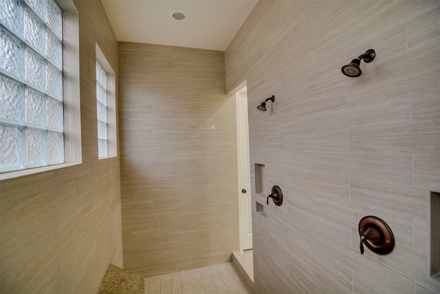 bathroom featuring tile walls and a tile shower