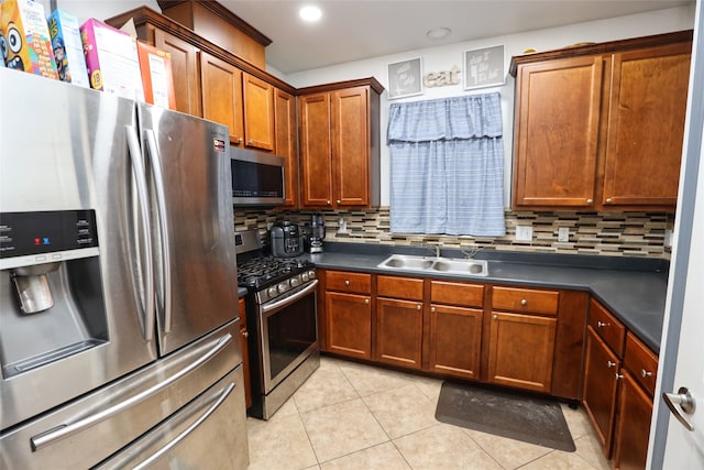 kitchen featuring light tile patterned floors, stainless steel appliances, tasteful backsplash, and sink