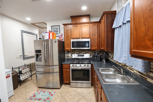 kitchen featuring sink, appliances with stainless steel finishes, light tile patterned floors, and tasteful backsplash