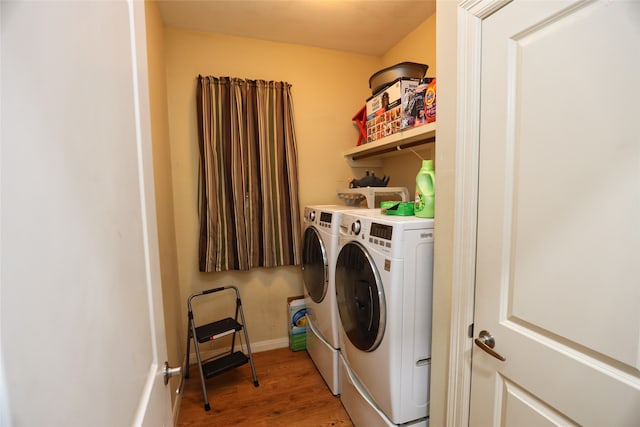 laundry room featuring washing machine and clothes dryer and hardwood / wood-style flooring