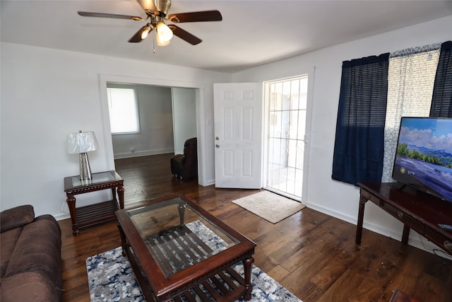 living room featuring a healthy amount of sunlight, dark wood-type flooring, and ceiling fan