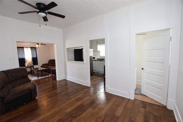 living room featuring ceiling fan and dark hardwood / wood-style floors