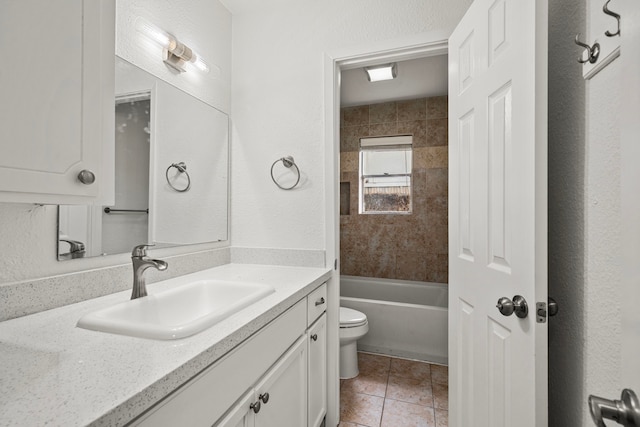 full bathroom featuring tile patterned floors, vanity, toilet, and tiled shower / bath combo