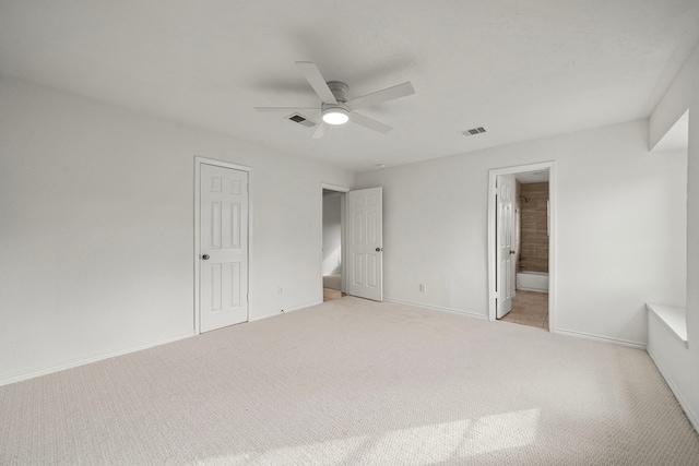 unfurnished bedroom with connected bathroom, a closet, light colored carpet, and ceiling fan