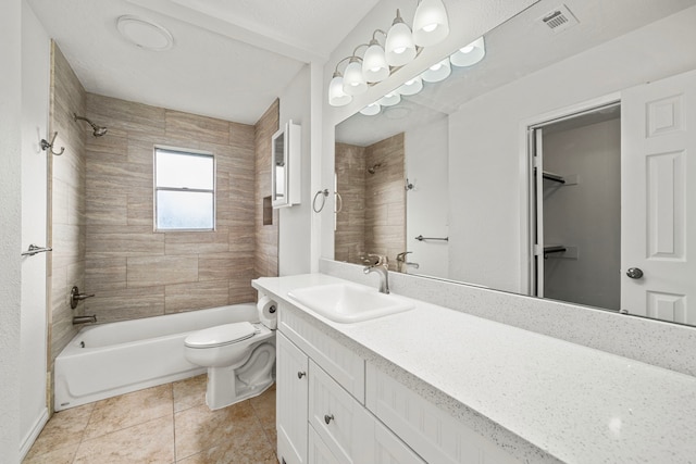 full bathroom with tile patterned flooring, vanity, tiled shower / bath combo, and toilet