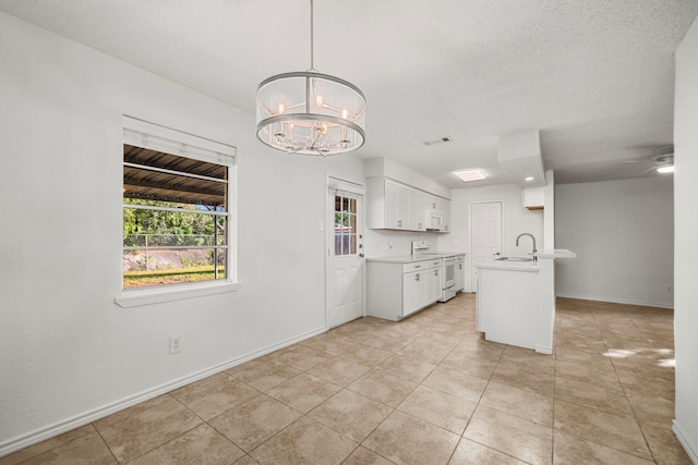 kitchen featuring white cabinetry, light tile patterned floors, pendant lighting, sink, and white appliances