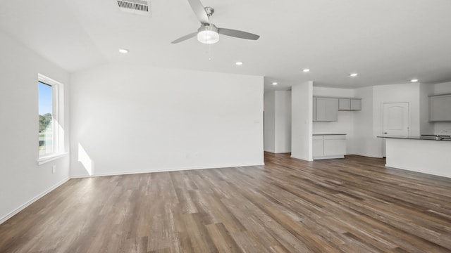 unfurnished living room with ceiling fan, dark hardwood / wood-style flooring, and vaulted ceiling