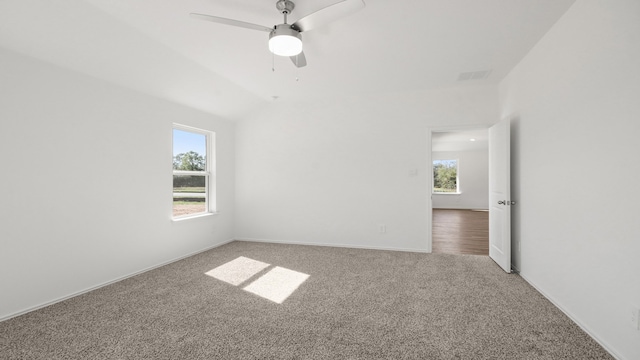 carpeted empty room with ceiling fan and plenty of natural light