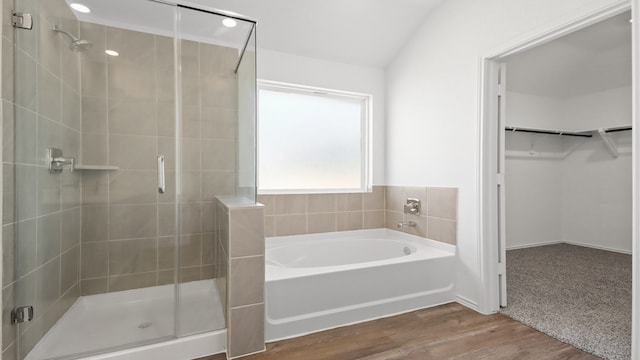 bathroom with hardwood / wood-style floors, lofted ceiling, and shower with separate bathtub