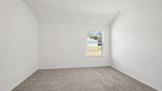 spare room with carpet flooring and lofted ceiling