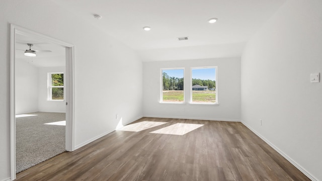 spare room featuring hardwood / wood-style floors, vaulted ceiling, ceiling fan, and a healthy amount of sunlight