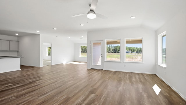 unfurnished living room featuring ceiling fan, light hardwood / wood-style floors, and vaulted ceiling