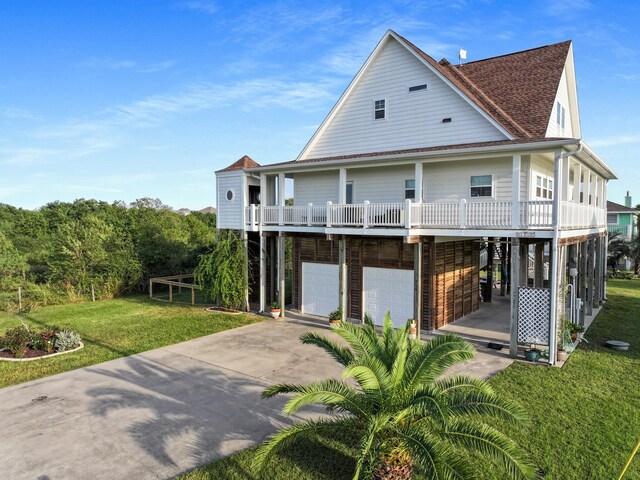 214 Biloxi, Crystal Beach, TX 77650 - back of house featuring concrete driveway, an attached garage, a yard, and a shingled roof