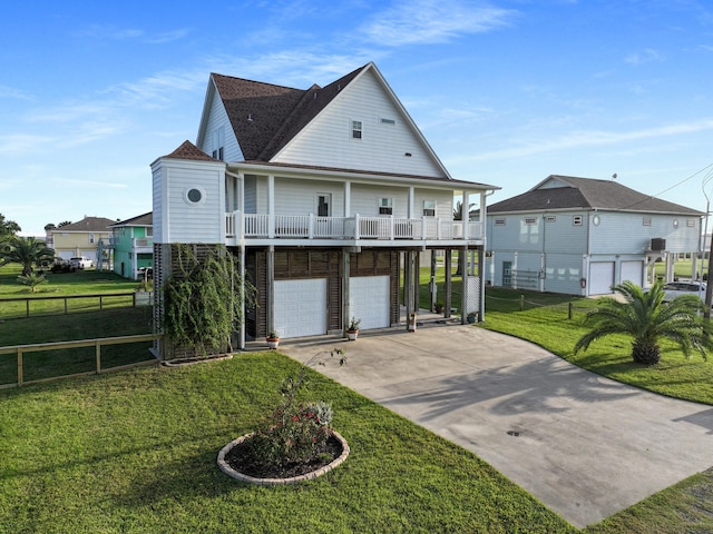 view of front of property featuring covered porch, a garage, and a front yard