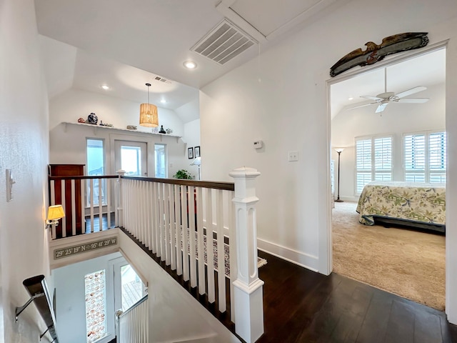 hallway with hardwood / wood-style floors and vaulted ceiling