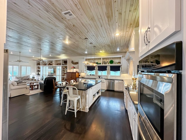 kitchen featuring wooden ceiling, stainless steel appliances, hanging light fixtures, a center island, and white cabinets