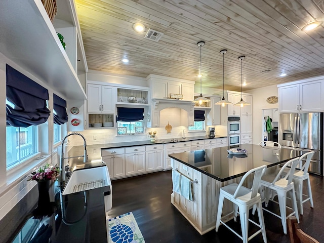 214 Biloxi, Crystal Beach, TX 77650 - kitchen with appliances with stainless steel finishes, dark countertops, open shelves, wood ceiling, and a kitchen bar