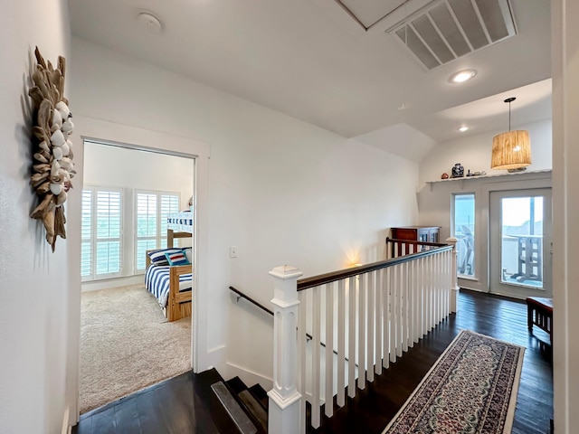 stairway featuring vaulted ceiling and hardwood / wood-style flooring