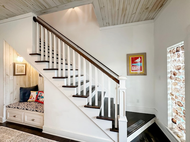 stairway featuring wooden walls, wood ceiling, and wood-type flooring