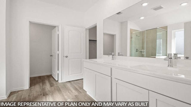 bathroom featuring hardwood / wood-style flooring, vanity, and an enclosed shower