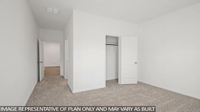 unfurnished bedroom with light colored carpet and a closet