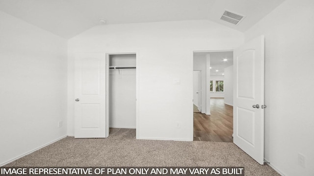 unfurnished bedroom with lofted ceiling and carpet