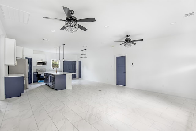 kitchen with a kitchen island, white cabinetry, appliances with stainless steel finishes, decorative light fixtures, and sink