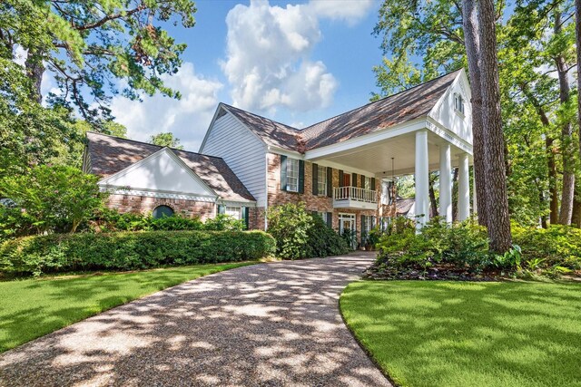 view of front of home featuring a balcony and a front yard