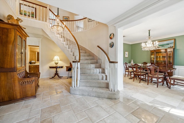 stairs with an inviting chandelier and ornamental molding