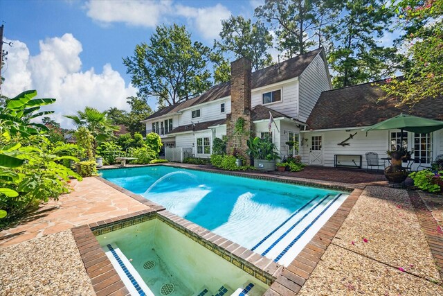 view of pool with an in ground hot tub and a patio