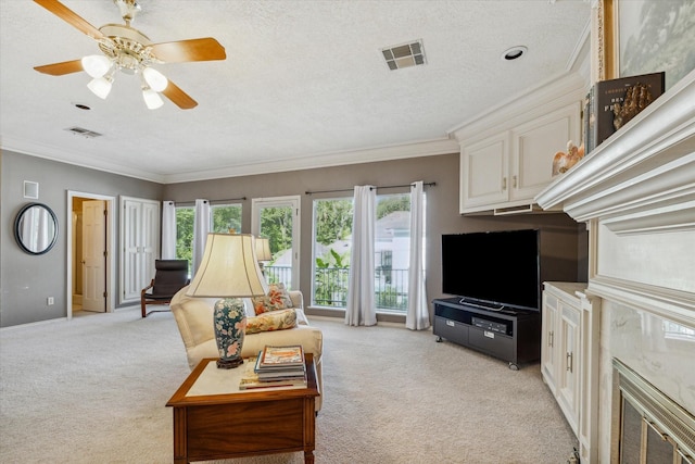 living room featuring light carpet, a textured ceiling, a fireplace, and crown molding